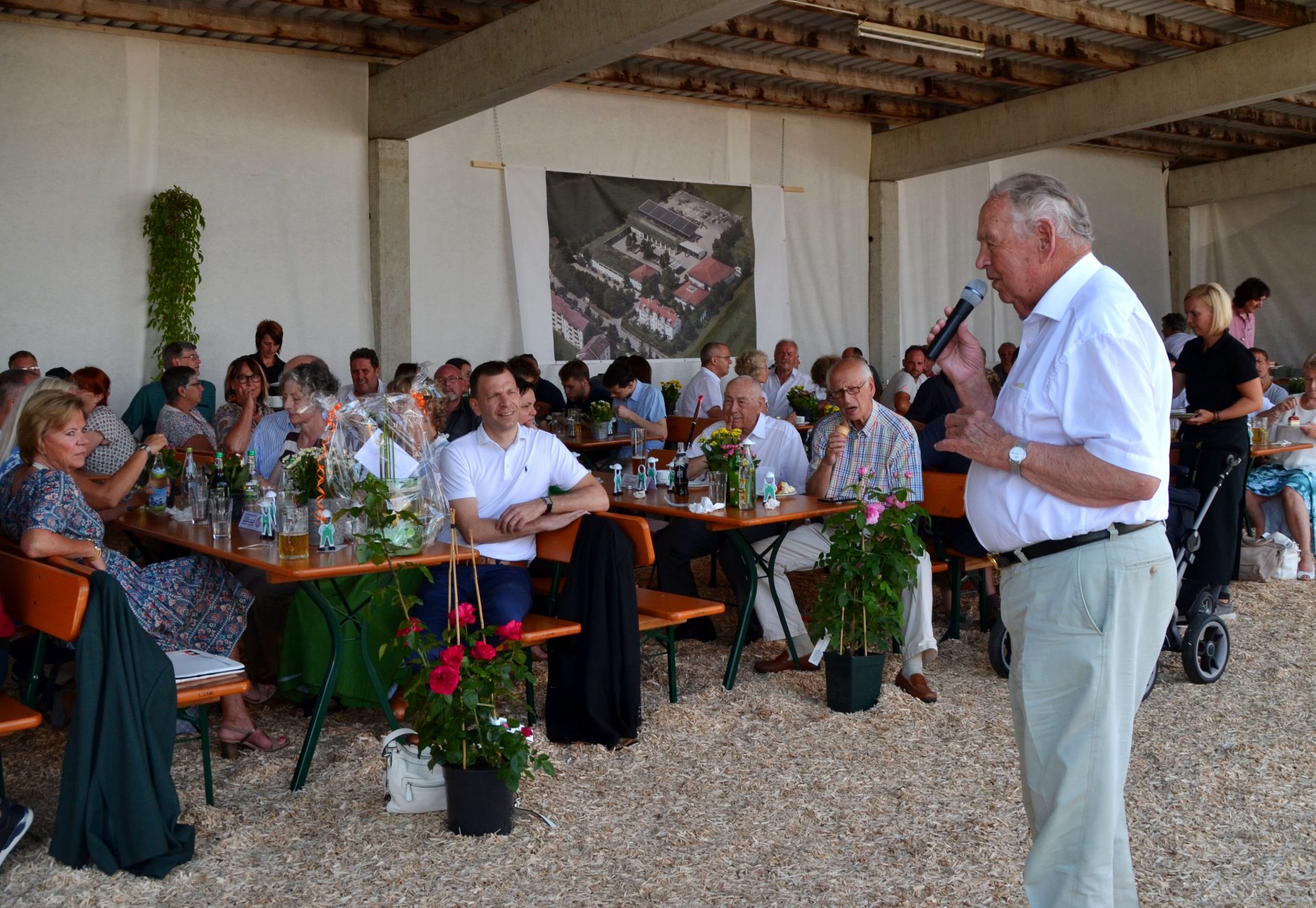 Firmengründer Hermann Kutter (84) schildert beim Sommerfest 2019, wie alles 1959 begann. Sein erster Auftrag: Hecke ausräumen, Rasen mähen, düngen und nachsäen für 55 DM.